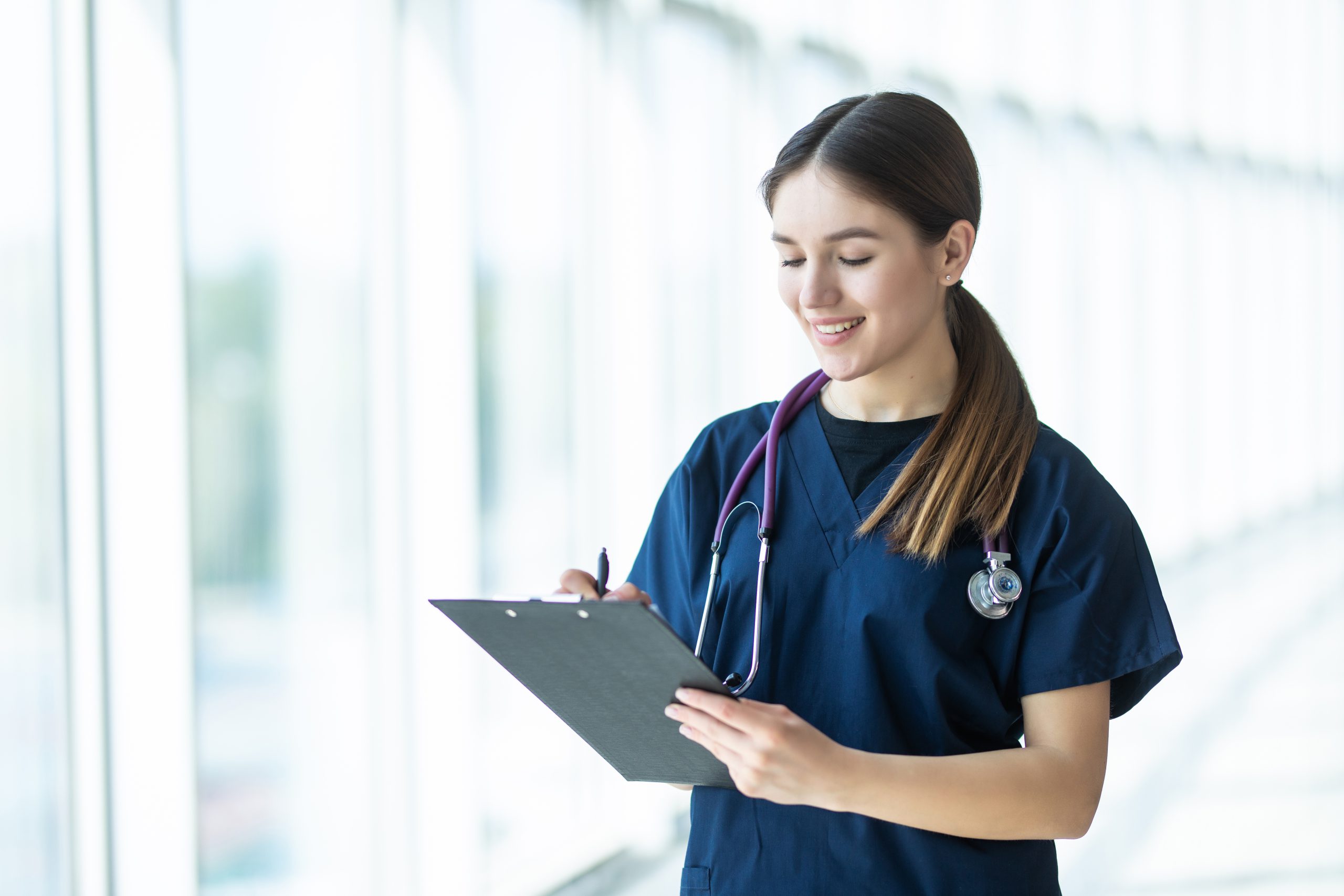 Smiling young female doctor holding a clipboard in hospital. healthcare concept